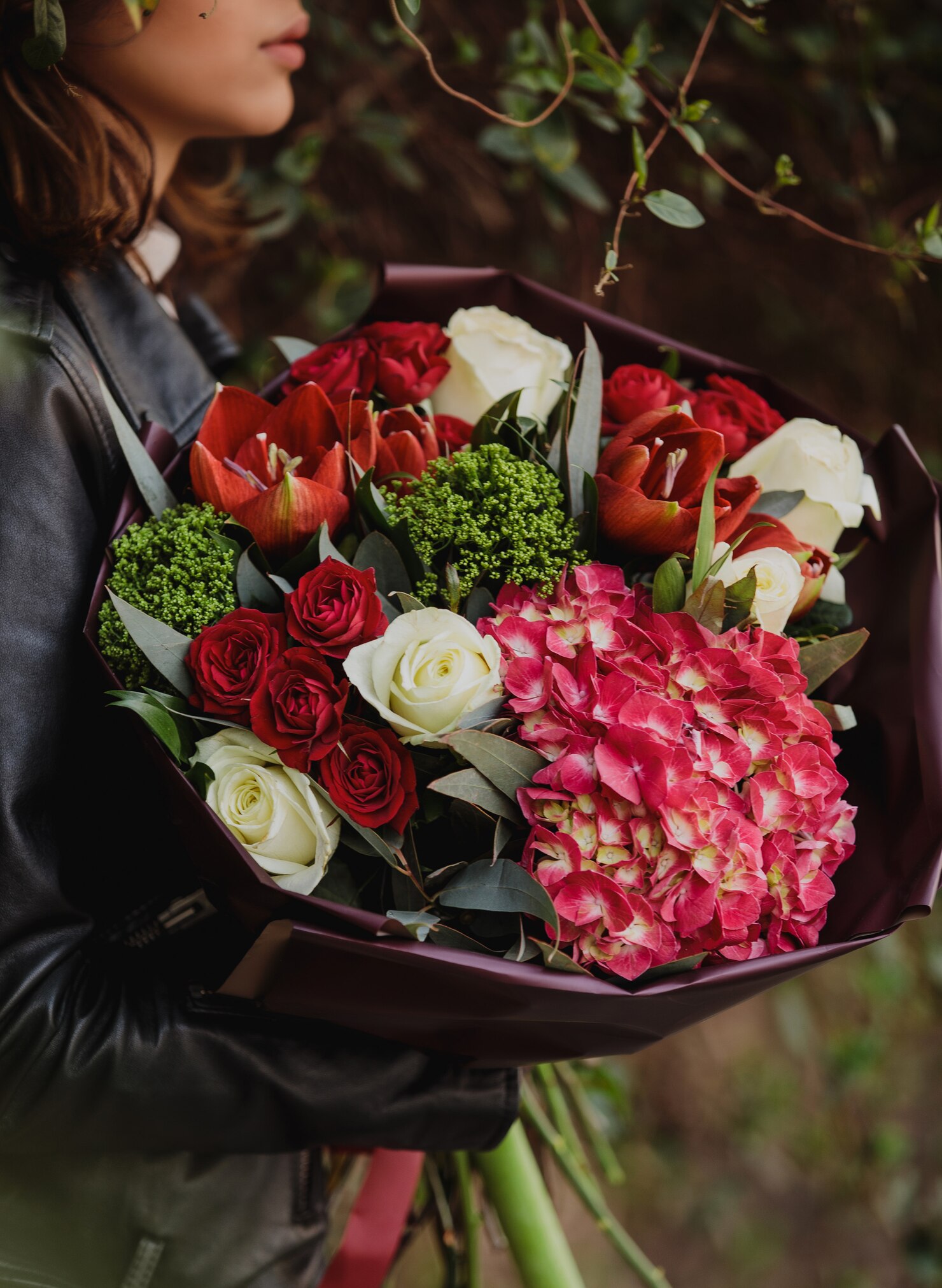 side-view-woman-holding-bouquet-white-red-color-roses-with-red-color-tulips-pink-color-hydrangea-trachelium-wall-flowers_140725-12874